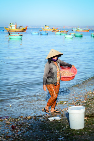 Phan Thiet, Vietnam - Mar 19, 2016. A woman working at Mui Ne fishing village in Phan Thiet, Vietnam. The bustling port city of Phan Thiet is traditionally known for its nuoc mam (fish sauce).のeditorial素材