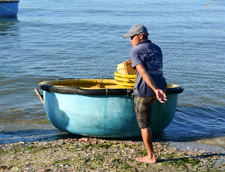Phan Thiet, Vietnam - Mar 19, 2016. A man with the basket boat in Phan Thiet, Vietnam. The bustling port city of Phan Thiet is traditionally known for its nuoc mam (fish sauce).のeditorial素材