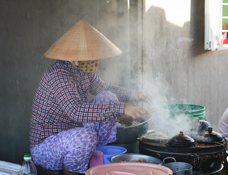 Mui Ne, Vietnam - Mar 19, 2016. A vendor cooking street foods in Mui Ne township, Phan Thiet,...