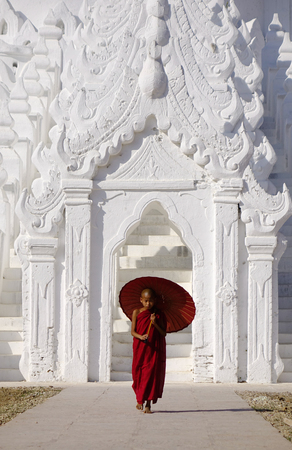A Buddhist novice standing at the White Temple in Mandalay, Myanmar. Mandalay is Burma cultural and religious center of Buddhism.のeditorial素材