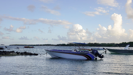 Grand Baie, Mauritius - Jan 11, 2017. Tourist boats waiting on the sea at sunset in Grand Baie,...