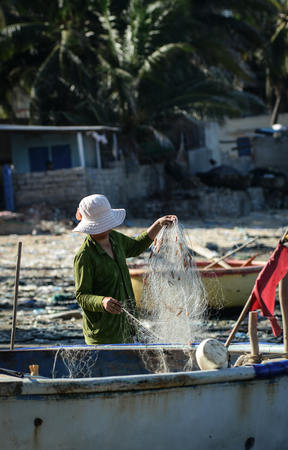 Binh Thuan, Vietnam - Jan 28, 2016. A woman working with nets in Binh Thuan, Vietnam. Vietnam is a country with a coastline 3400 km long, with many beautiful coastal cities.のeditorial素材