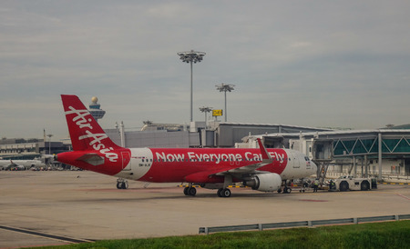 Singapore - Dec 14, 2015. An AirAsia airplane docking at the Changi International Airport in Singapore. Changi is one of the largest transportation hubs in Southeast Asia.のeditorial素材