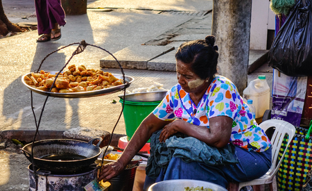 Yangon, Myanmar - Feb 13, 2017. A vendor selling foods on street in Yangon, Myanmar. Yangon is the country largest city with a population above 7 million.のeditorial素材