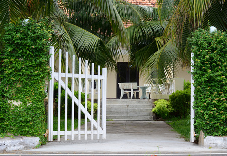 White picket fence with green trees at sunny day in the gardenの写真素材