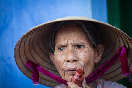 Hoi An, Vietnam - Dec 1, 2015. Portrait of old woman on street in Hoi An Ancient Town, Vietnam. Hoi An is Vietnam most atmospheric and delightful town.のeditorial素材