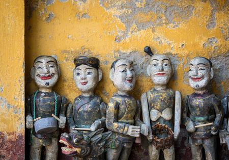 Traditional wooden dolls (puppets) with vintage wall in Hoi An, Vietnam.の写真素材