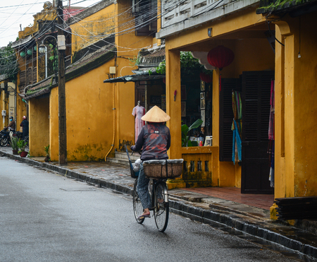 Hoi An, Vietnam - Nov 28, 2015. A vendor biking on main street in Hoi An Ancient Town, Vietnam. Hoi An is Vietnam most atmospheric and delightful town.のeditorial素材