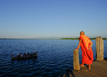 Mandalay, Myanmar - Oct 18, 2015. A monk standing on Ubein Bridge in Mandalay, Myanmar. The bridge...
