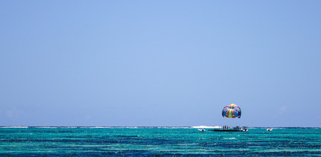 Parasailing on tropical sea and turquoise water at sunny dayの写真素材