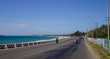 Nha Trang, Vietnam - Mar 26, 2017. Vehicles run on the highway near the tropical sea in Vietnam. The total length of the Viet Nam road system is about 222,179 km.のeditorial素材