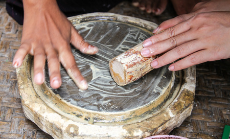 Burmese woman made powder thanaka from ground barkの写真素材