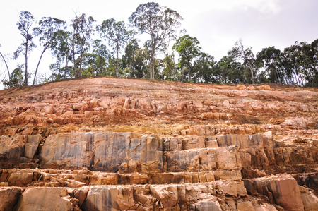 Rock hill with green trees at the sunny day in summer time.の写真素材