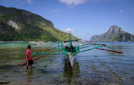 El Nido, Philippines - Apr 7, 2017. People with the traditional wooden boat in El Nido, Philippines. El Nido is a coastal settlement and major tourist destination in Philippines.のeditorial素材