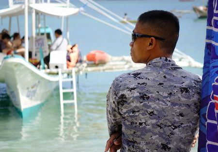 El Nido, Philippines - Apr 7, 2017. A soldier standing on the beach in El Nido, Philippines. El Nido is a coastal settlement and major tourist destination in Philippines.のeditorial素材