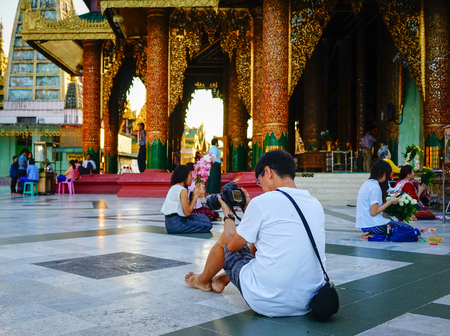 Yangon, Myanmar - Oct 16, 2015. Tourists sitting at Shwedagon Paya in Yangon, Myanmar. Shwedagon is the famous sacred place and tourist attraction landmark in Yangon, Myanmar.のeditorial素材