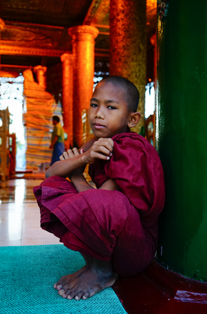 Yangon, Myanmar - Oct 16, 2015. A novice boy sitting at Shwedagon Paya in Yangon, Myanmar. Shwedagon is the famous sacred place and tourist attraction landmark in Yangon, Myanmar.のeditorial素材
