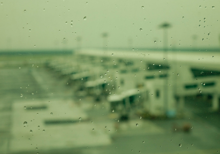 Water drops on glass window with airport backgroundの写真素材