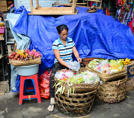Bali, Indonesia - Apr 21, 2016. A woman selling praying flowers at Central Market in Bali, Indonesia. Bali is a popular tourist destination, which has seen a significant rise in tourists.のeditorial素材