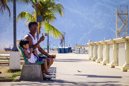 Palawan, Philippines - Apr 11, 2017. A man with his son relax at El Nido Seaside Park in Palawan, Philippines. The Palawan coast is one of the most unspoilt places in the world.のeditorial素材