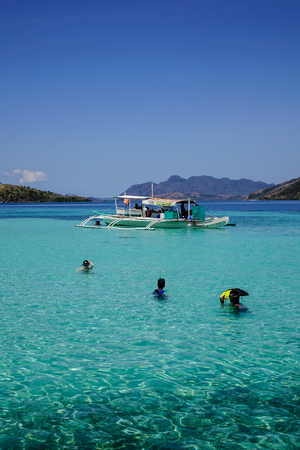 Palawan, Philippines - Apr 11, 2017. Tourists swimming on the sea under blue sky in Palawan, Philippines. The Palawan coast is one of the most unspoilt places in the world.のeditorial素材
