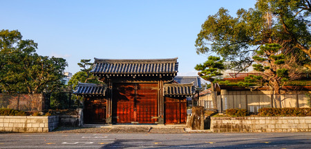 A wooden gate of the ancient palace at sunny day in Kyoto, Japan. Kyoto is famous for its numerous classical Buddhist temples, as well as gardens and imperial palaces.のeditorial素材