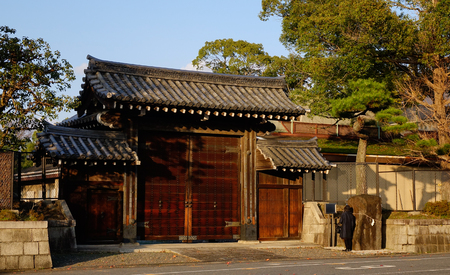 A wooden gate of the ancient palace at sunny day in Kyoto, Japan. Kyoto was the capital of Japan for...