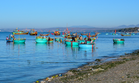 Nha Trang, Vietnam - Mar 19, 2016. People with wooden boats at the fishing village in Nha Trang, Vietnam. Nha Trang is a seaside town on the South Central Coast of Vietnam.のeditorial素材