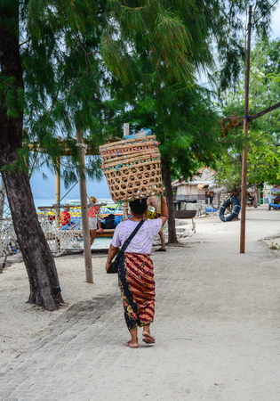 Lombok, Indonesia - Apr 17, 2016. People walking on rural road at Gili Islands in Lombok, Indonesia. Lombok is known for beaches and surfing spots, particularly at Kuta and Banko Banko.のeditorial素材