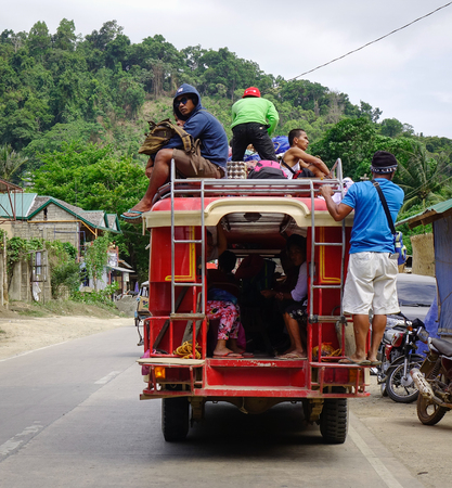 El Nido, Philippines - Apr 4, 2017. Jeepney carrying many people on street in El Nido, Philippines. El Nido is known for its sand beaches, coral reefs, and as the gateway to small islands.のeditorial素材