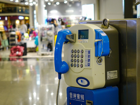 HONG KONG, CHINA - APR 1, 2017. Public fixed telephone booth at the airport in Hong Kong, China. The Hong Kong airport handles more than 70m passengers per year.のeditorial素材