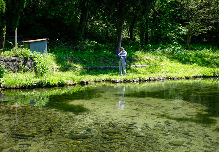Akita, Japan - May 18, 2017. A man standing at green forest with a lake in Akita, Japan. Akita is a large prefecture at the Sea of Japan coast in the northern Tohoku Region.のeditorial素材