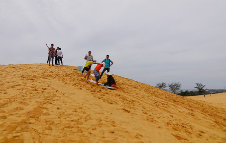 Mui Ne, Vietnam - Mar 26, 2017. Tourists playing on the sand dunes in Mui Ne, Vietnam. Sand Dunes just outside of Mui Ne are one of Vietnam charming geological oddities.のeditorial素材
