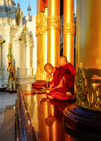 Yangon, Myanmar - Oct 16, 2015. Monks sit at Shwedagon Pagoda in Yangon, Myanmar. Shwedagon is the most famous pagoda in the world and a must see place in Yangon.のeditorial素材