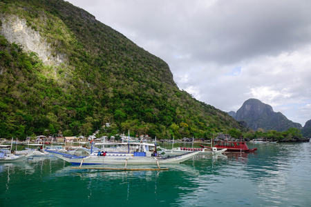 El Nido, Philippines - Apr 8, 2017. Wooden boats docking at El Nido Ports in Philippines. El Nido is known for its sand beaches, coral reefs, and as the gateway to small islands.のeditorial素材