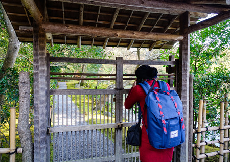 Kyoto, Japan - Dec 26, 2015. A young tourist taking pictures at a zen-like garden in Kyoto, Japan....