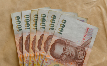 Thai Bath banknotes (1000 bath) on textile background - close up.