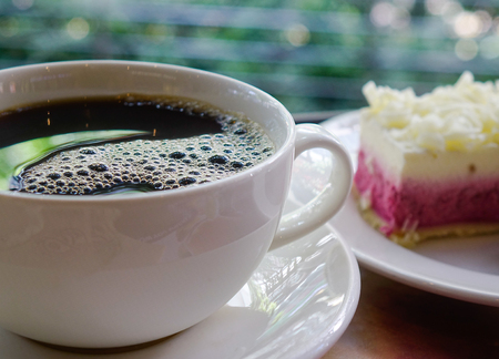 Cup of black coffee with cheese cake at sunny day. Close up.の写真素材