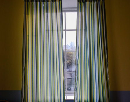 Sunrise through transparent curtains of a window in the morningの写真素材