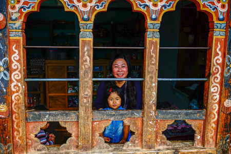 Thimphu, Bhutan - Aug 29, 2015. A Tibetan woman with her child at a traditional house in Thimphu, Bhutan. Bhutan is a small country in the Himalayas between Tibet and India.のeditorial素材