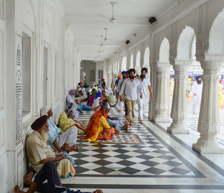 Amritsar, India - Jul 25, 2015. Sikh people relax at the Golden Temple in Amritsar, India. Golden...