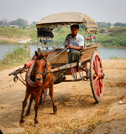 Mandalay, Myanmar - Feb 22, 2016. Horse cart at Innwa Town in Mandalay, Myanmar. Innwa is an ancient capital of successive Burmese kingdoms from the 14th to 19th centuries.のeditorial素材