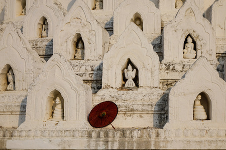 A red umbrella at Hsinbyume (Mya Thein Dan pagoda) at sunny day in Mingun, Mandalay, Myanmar. Hsinbyume is a beautiful all white pagoda built in 1816.の写真素材