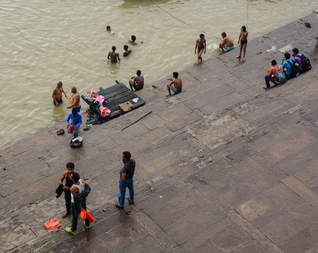Varanasi, India - Jul 12, 2015. People bathing on Ganges River at sunny day in Varanasi, India. Varanasi draws Hindu pilgrims who bathe in the Ganges River sacred waters.のeditorial素材