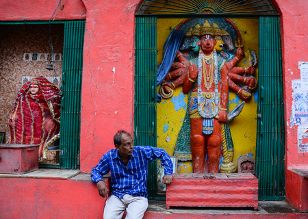 Varanasi, India - Jul 11, 2015. An Indian man sitting at ancient Hindu temple in Varanasi, India. Varanasi draws Hindu pilgrims who bathe in the Ganges River sacred waters.のeditorial素材