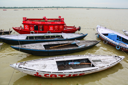 Varanasi, India - Jul 11, 2015. Wooden boats on Ganges River at sunny day in Varanasi, India. Varanasi draws Hindu pilgrims who bathe in the Ganges River sacred waters.のeditorial素材
