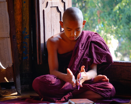 Nyaungshwe, Myanmar - Feb 14, 2016. A young monk sitting at Shwe Yan Pyay Monastery in Nyaungshwe, Myanmar. Nyaungshwe is a township of Taunggyi in the Shan State of Myanmar.のeditorial素材