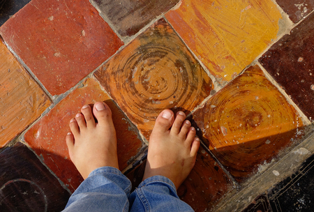 Vintage tile floor with man foot at a temple in Shan State, Myanmar.