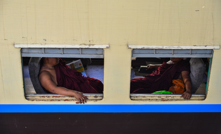 Yangon, Myanmar - Feb 13, 2017. Monks sitting on the train at station in Yangon, Myanmar. Yangon is Myanmar largest city and its most important commercial centre.のeditorial素材