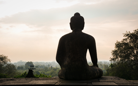 A Buddha statue at Borobudur Temple on Java, Indonesia. Borobudur, located in Java, is the largest Buddhist temple in the world.の写真素材